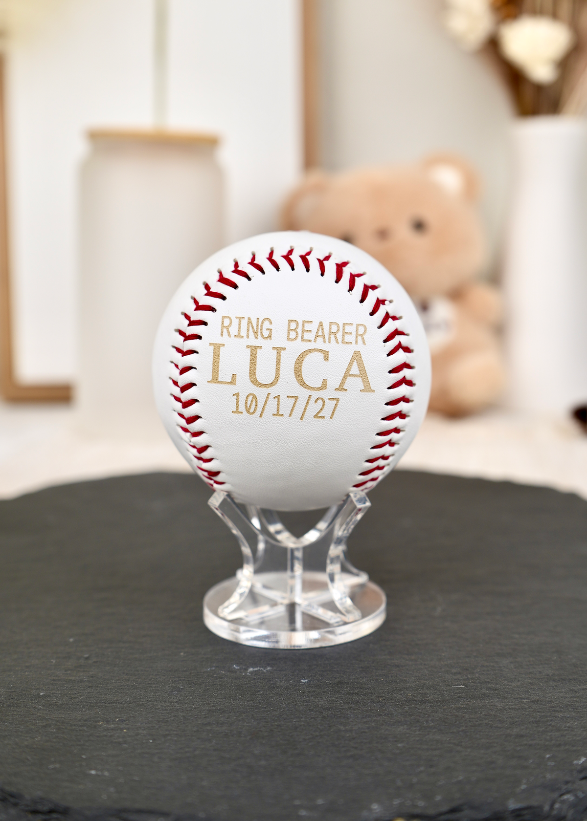 a personalized baseball with "ring bearer Luca 10/17/27" engraved on it. baseball is on a clear acrylic stand. proposal ring bearer gift