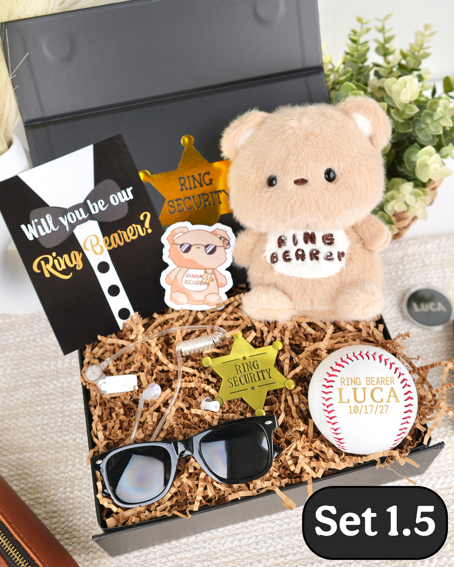 A personalized plush teddy bear gift set labeled 'Set 1.5' in a black tray filled with shredded paper.